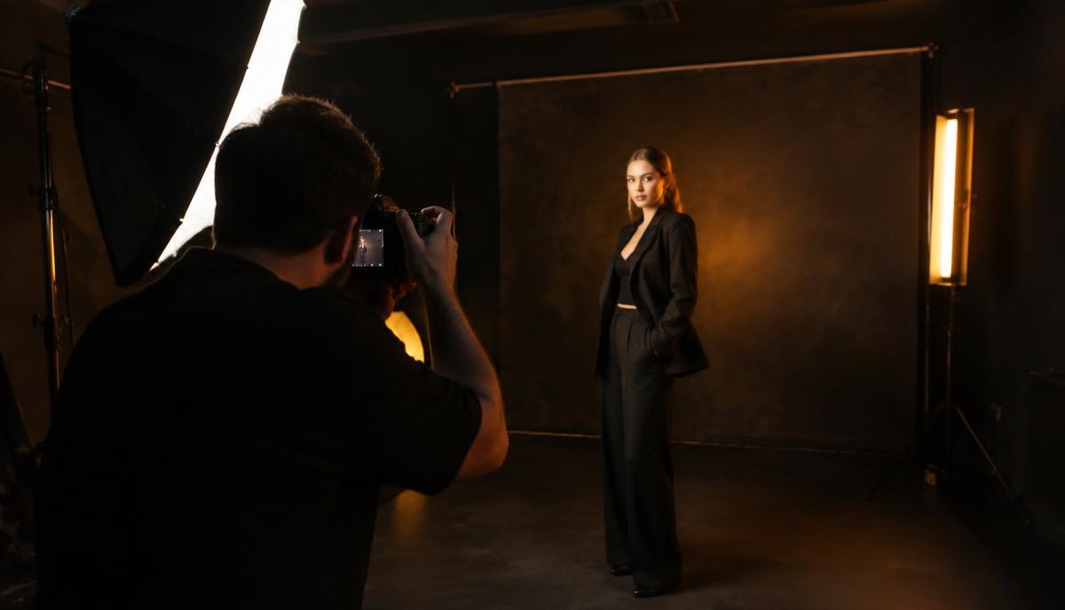 Professional portfolio photoshoot in progress with a photographer, studio lighting and dark backdrop